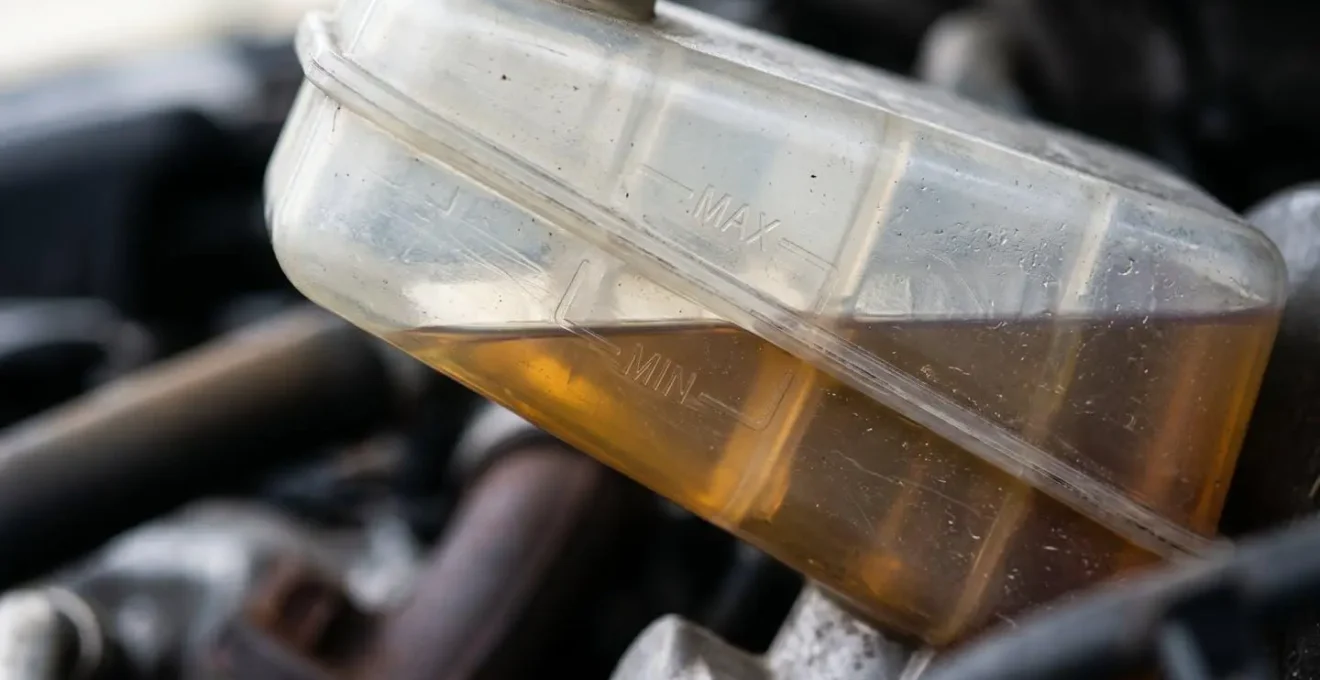 Gros plan sur un réservoir de liquide de frein avec niveau visible et repères min/max
